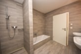 Modernes Badezimmer - Neuwertige 3 Zi-Wohnung im 1. OG mit Personenaufzug, Kellerraum und 2 PKW – Stellplätzen in Messel!